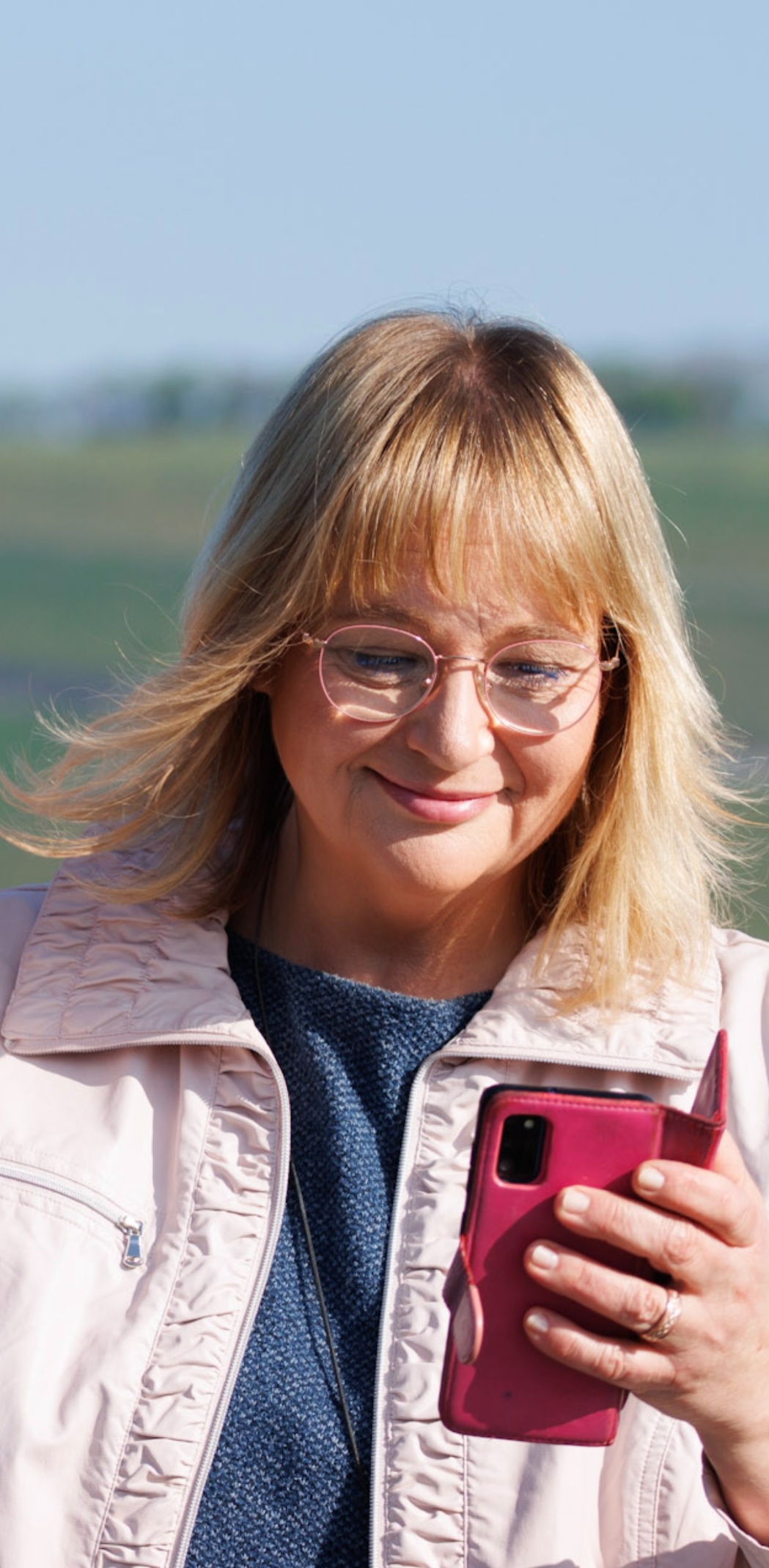 Andrea schaut sanft lächelnd auf ihr Handy