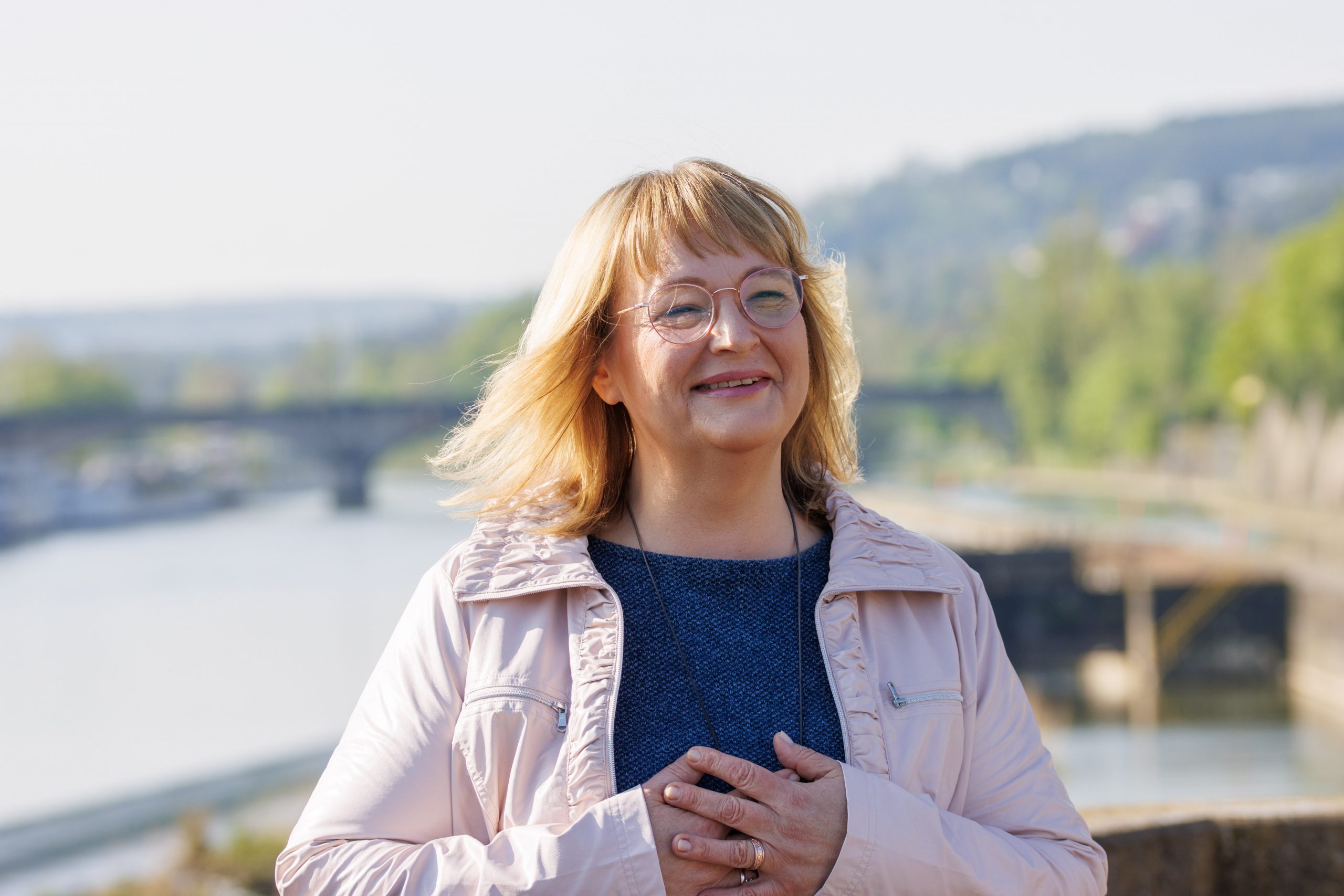Andrea hat die Augen geschlossen, das Gesicht und die Hände, glücklich lächelnd dem Himmel entgegen gehoben.